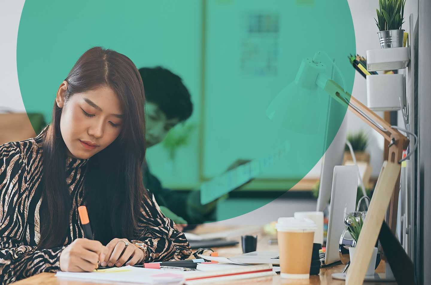 A woman sitting at a desk writing by hand