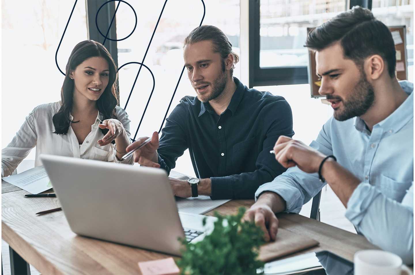 three people sitting around a laptop